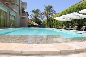piscina con sedie e ombrellone di b&b Villa Grazia a Leverano