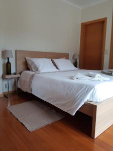a bedroom with a large bed with a wooden headboard at Casa da Calçada in Mujães