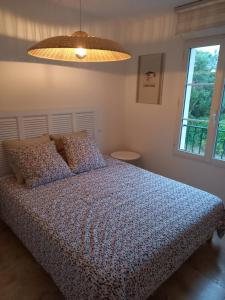 een slaapkamer met een bed, een lamp en een raam bij Appartement premium T3 résidence piscine in La Croix-Valmer