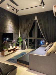 1 dormitorio con cama, sofá y TV en Niks Troika Homestay, en Kota Bharu