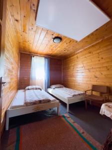 a room with two beds in a wooden cabin at Phoenix in Praid