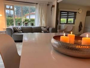 una sala de estar con una mesa con velas. en Freestanding Holiday Home BEEKBERGEN - WASMACHINE ALL COUNTRY TV CHANNELS, en Beekbergen
