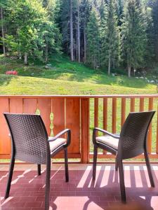 two chairs sitting on a porch with a view at Appartamento Campiglio 2 in Madonna di Campiglio