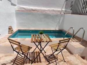una mesa y sillas junto a una piscina en Casa del Portillete, en Montejaque