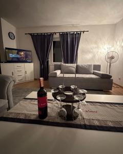 een woonkamer met een fles wijn op een tafel bij Bosnian Hobbiton in Kovačevo Polje