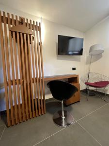 a living room with a black chair and a television at Hotel El Rosal de Cudillero in Cudillero