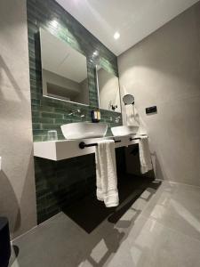 a bathroom with two sinks and a mirror at Hotel El Rosal de Cudillero in Cudillero