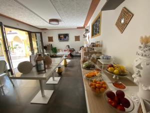 a room with long tables filled with fruits and vegetables at RIAD Comfort Rooms in San Vito lo Capo