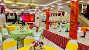 un salón de banquetes con mesas y sillas verdes y amarillas en Kashish Residency and Banquet, en Noida