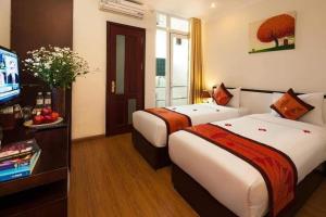 a hotel room with two beds and a flat screen tv at Rising Dragon Hotel in Hanoi