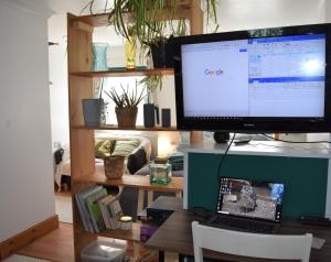 a computer monitor sitting on a desk with a laptop at The Owl Box: self-contained private annex & garden in Horseheath