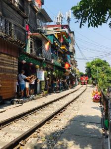 a group of people standing next to a train station at Rising Dragon Hotel in Hanoi