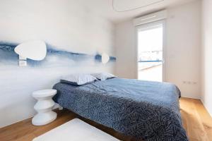 a white bedroom with a bed and a window at Casa de Marseille in Marseille