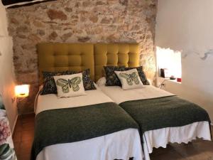 um quarto com uma cama grande e uma parede de tijolos em Las Casas del Rincón -4 dormitorios em Villahermosa