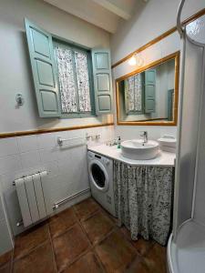 a bathroom with a sink and a washing machine at Las Casas del Rincón -4 dormitorios in Villahermosa