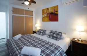 a bedroom with a bed with a checkered blanket at Altea Mar y Puerto in Altea
