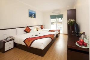 a bedroom with two beds and a television in it at Rising Dragon Hotel in Hanoi