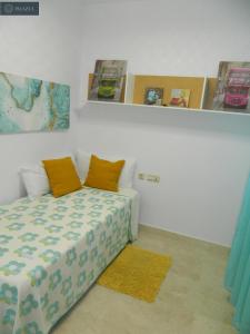 um quarto com uma cama com almofadas laranja em BLUE 470 em Isla Cristina