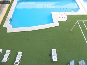 uma vista superior de uma piscina com três cadeiras em BLUE 470 em Isla Cristina