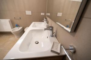 a bathroom with a white sink and a toilet at CASA ALEF in Manduria