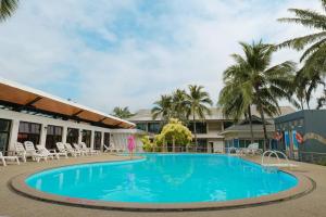 a pool at the resort with chairs and palm trees at Chaolao Tosang Beach Hotel in Chao Lao Beach
