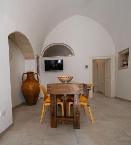 a dining room with a table and chairs and a vase at CASA ALEF in Manduria