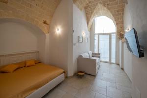 a bedroom with a bed and a tv in a room at CASA ALEF in Manduria