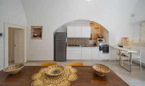 eine Küche mit einem Holztisch, auf dem Schüsseln stehen in der Unterkunft CASA ALEF in Manduria