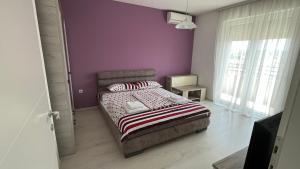1 dormitorio con cama y pared púrpura en Harmony Relax, en Paraćin