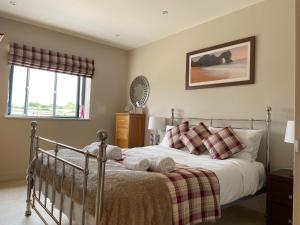 1 dormitorio con cama y ventana en The Paddocks - Spacious annexe with rural outlook., en Wareham