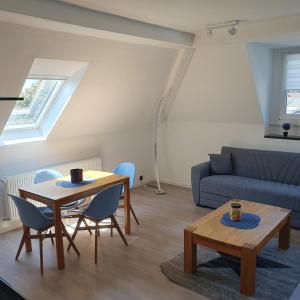 sala de estar con mesa, sillas y sofá en Ferienwohnung Fernblick en Remscheid