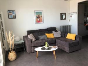 ein Wohnzimmer mit einem Sofa und einem Tisch in der Unterkunft Appartement sur la plage de Malo les bains vue mer in Dunkerque