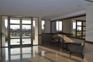 a living room with a table and chairs and windows at Apartamento Nicolás Tirado in Antofagasta
