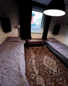 1 Schlafzimmer mit 2 Einzelbetten und einem Fenster in der Unterkunft Retro bungalow in Liepāja