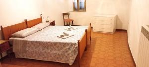 Un dormitorio con una cama con dos zapatos. en casa con 2 camere in borgo medievale, en Montegiovi