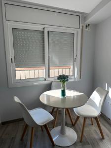 a table and two chairs in a room with two windows at Luxury apartament in Perelló
