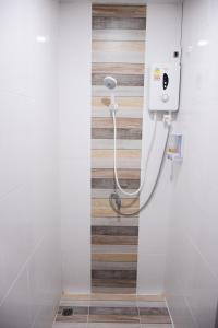 um chuveiro na casa de banho com uma parede de madeira em นอน นี่ นะ โฮสเทล Noen nee Na Hostel em Ban Non Na Yao