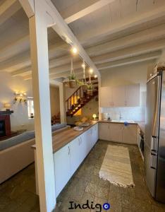una gran cocina con armarios blancos y una escalera en Poseidonia The Greek Lifestyle, en Lambírion
