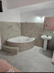 a bathroom with a bath tub and a sink at Hostal Pompeya Merida in Merida