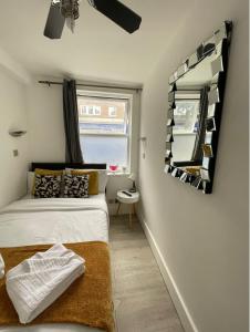 1 dormitorio con cama y espejo en la pared en ND Hotel - Hyde Park, en Londres