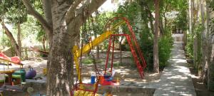 einen Spielplatz in einem Park mit einem Baum in der Unterkunft Villa Anna in Palaiochóra