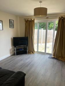 a living room with a television and sliding glass doors at House number 4 Sleeps up to 5 with Smart TVs in every room in Wellington