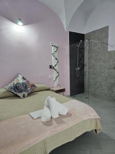 um quarto com um chuveiro e uma cama com toalhas em Hostal Pompeya Merida em Mérida