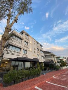 a white building with an awning next to a street at Avion Suite Hotel in Antalya