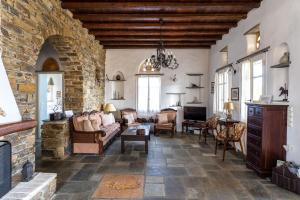 a living room with a stone wall at Maison Simone with private heated infinity pool & spectacular sea view in Agios Sostis