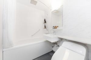 a white bathroom with a sink and a mirror at The knot Sapporo - Vacation STAY 96374v in Sapporo