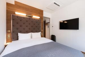 a bedroom with a large bed and a flat screen tv at The knot Sapporo - Vacation STAY 96374v in Sapporo