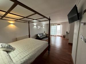 a bedroom with a canopy bed and a living room at Suite en estancia maravillosa y romántica ideal parejas in Pineda de Mar