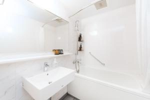 La salle de bains blanche est pourvue d'un lavabo et d'une douche. dans l'établissement The not Sapporo - Vacation STAY 96529v, à Sapporo