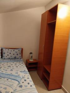 コスティネシュティにあるVila La Foisorのベッドルーム1室(ベッド1台付)、木製キャビネットが備わります。